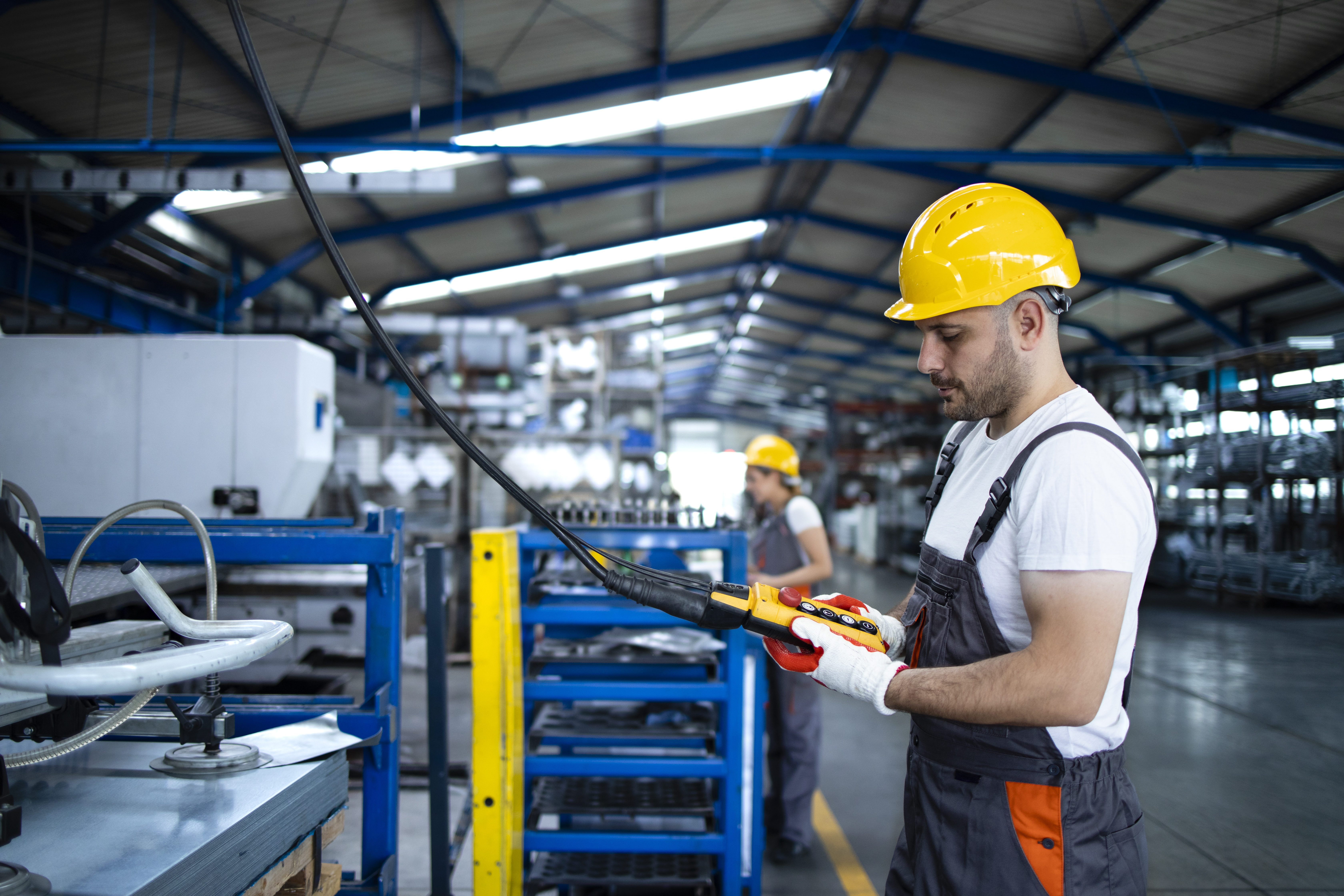 factory-worker-wearing-uniform-hardhat-operating-industrial-machine-with-push-button-joystick-production-hall.jpg